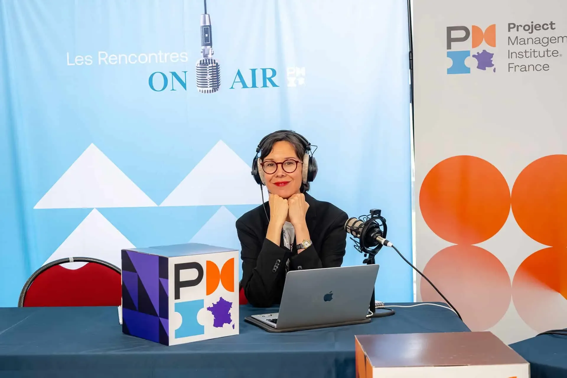 Journaliste au micro sur le plateau radio des Rencontres On Air, PMI France, 2026.